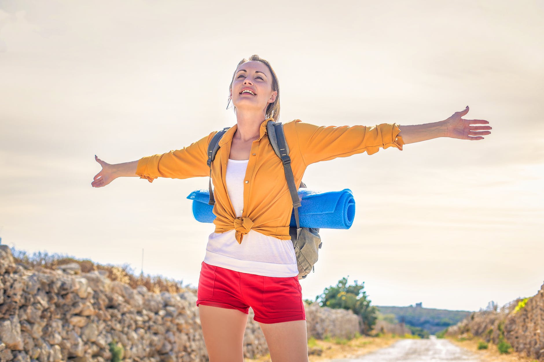 woman in yellow long sleeve standing under the sunlight